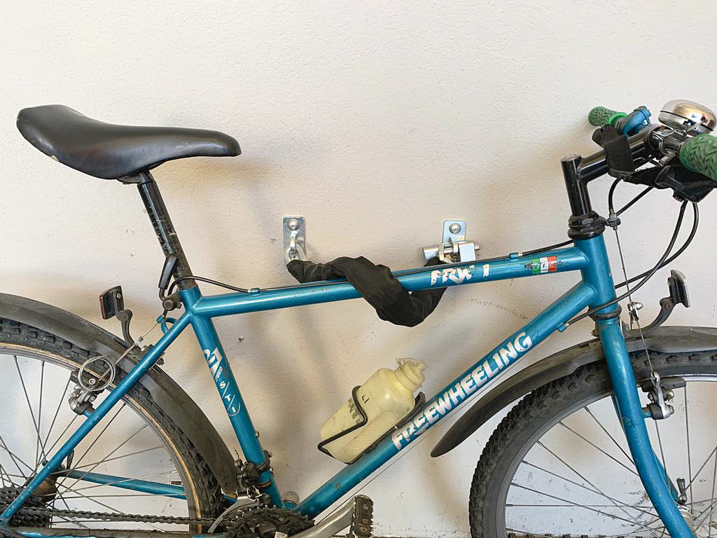 Bicicletta fissata al muro con ancora di sicurezza MINUTEX e guaina antigraffio.