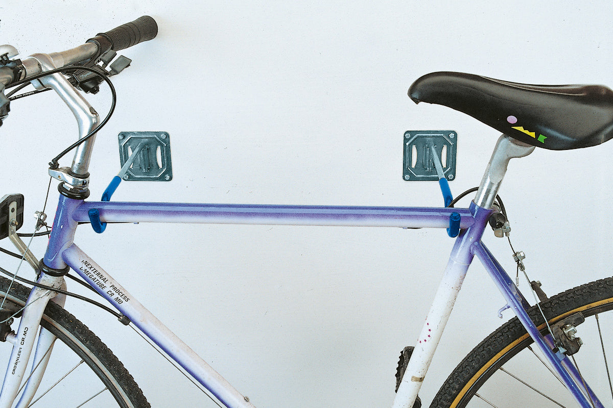 Supporti pieganti per bicicletta MINUTEX fissati a parete bianca.