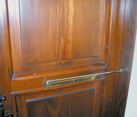 Sicura regolabile MINUTEX in acciaio zincato nero per anta da 40 cm su porta in legno.
