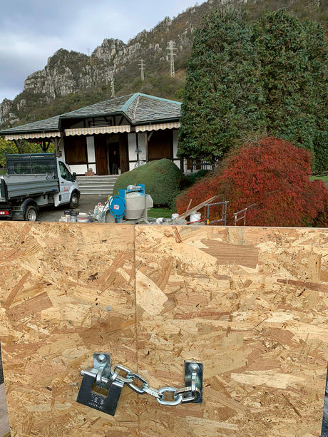 Ancoraggio di sicurezza MINUTEX in acciaio zincato con catena e lucchetto su pannello OSB