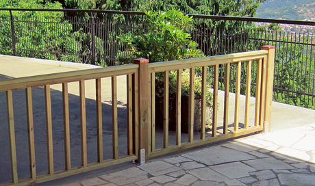 Ringhiera in legno per terrazza esterna con pianta in vaso e vista sul paesaggio.