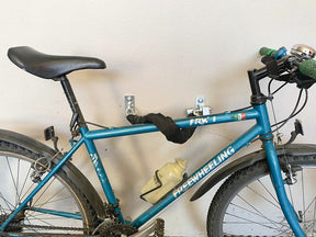 Bicicletta fissata al muro con ancora di sicurezza MINUTEX e guaina antigraffio.