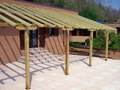 Struttura in legno per pergola da giardino montata su patio in pietra.