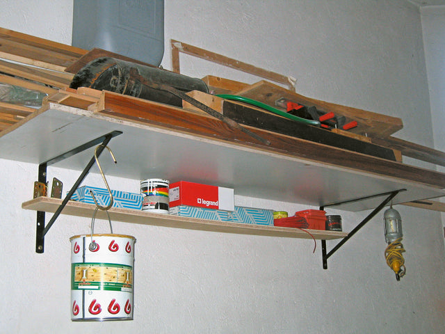 Mensola Genius di Minutex grigia utilizzata per organizzare attrezzi e barattoli in officina.
