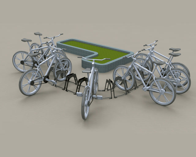 Biciclette parcheggiate presso rastrelliere in un'area verde con bordi in pietra.