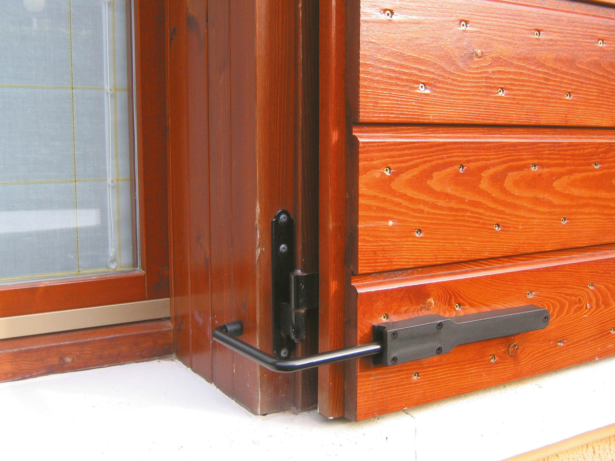 Fermaporta esterno Minutex con molla nero da 180 mm montato su porta in legno